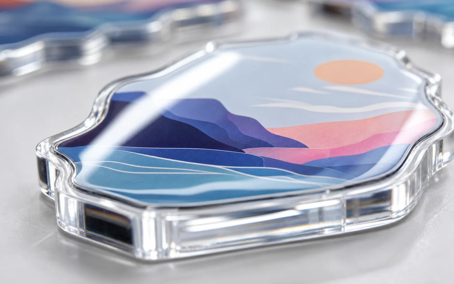 Close-up of a glossy UV-printed acrylic charm with a layered sunset landscape