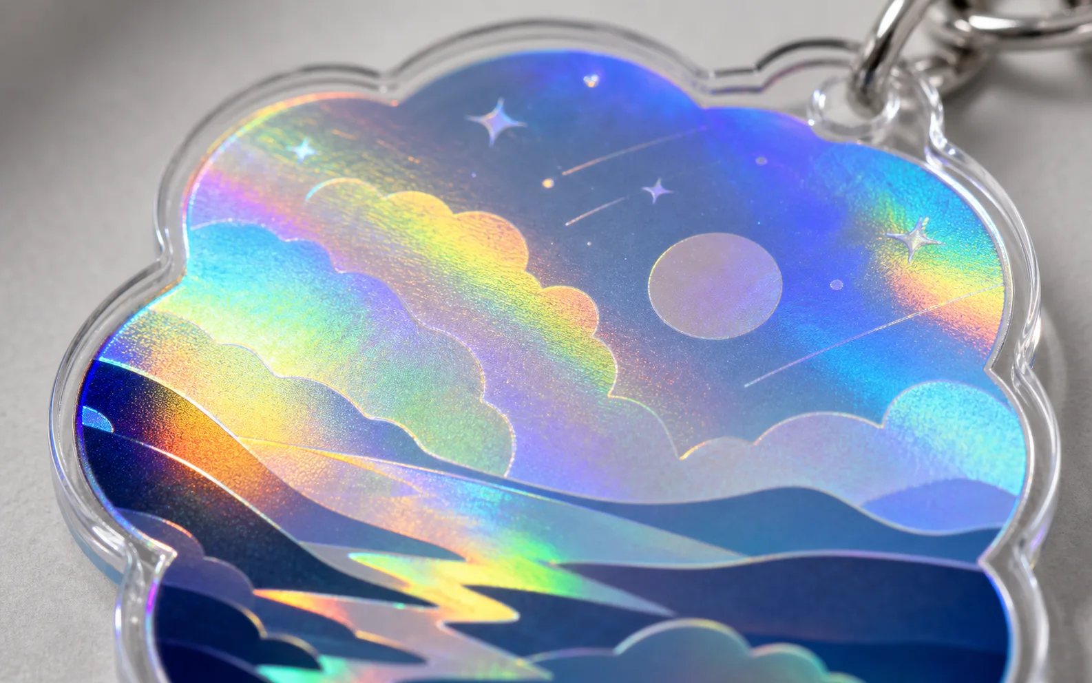 Extreme close-up of a holographic acrylic charm — a rainbow cloudscape sealed under polished clear acrylic