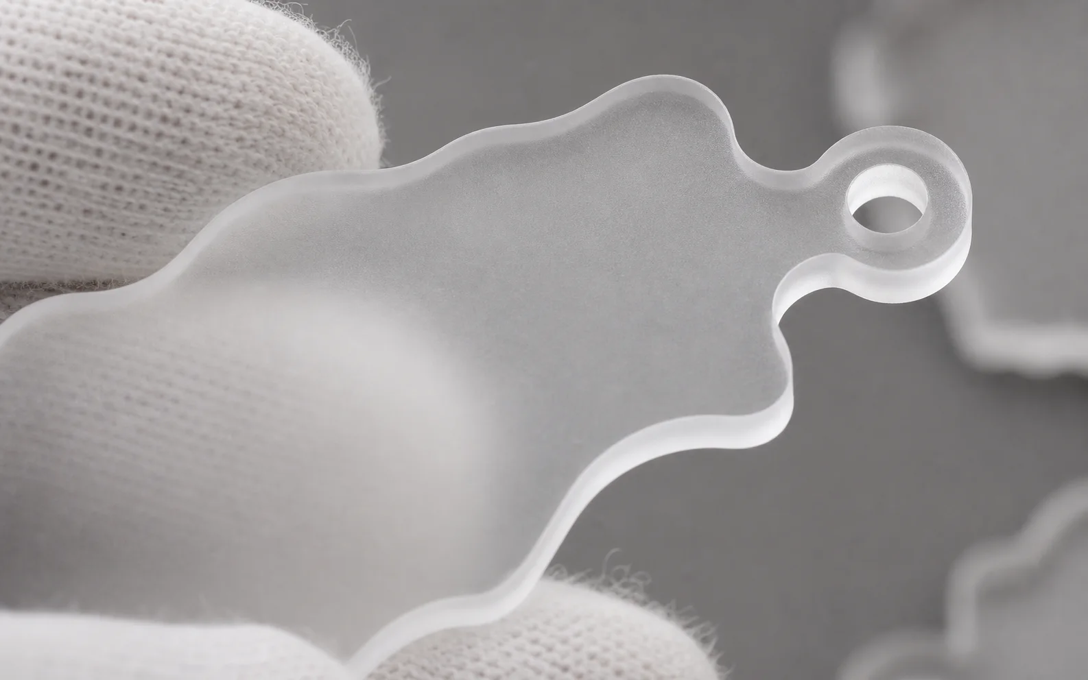 Die-cut frosted acrylic blank with hanging hole — clip hardware is fitted during assembly